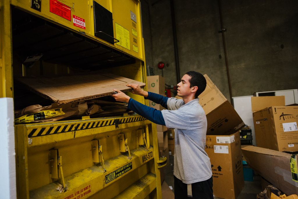 Our employee is hard at work recycling cardboard and boxes.