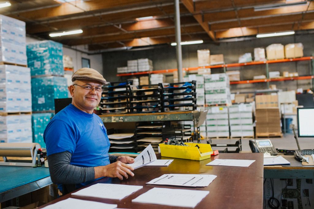 Our team member organizes invoices and paperwork in the warehouse.