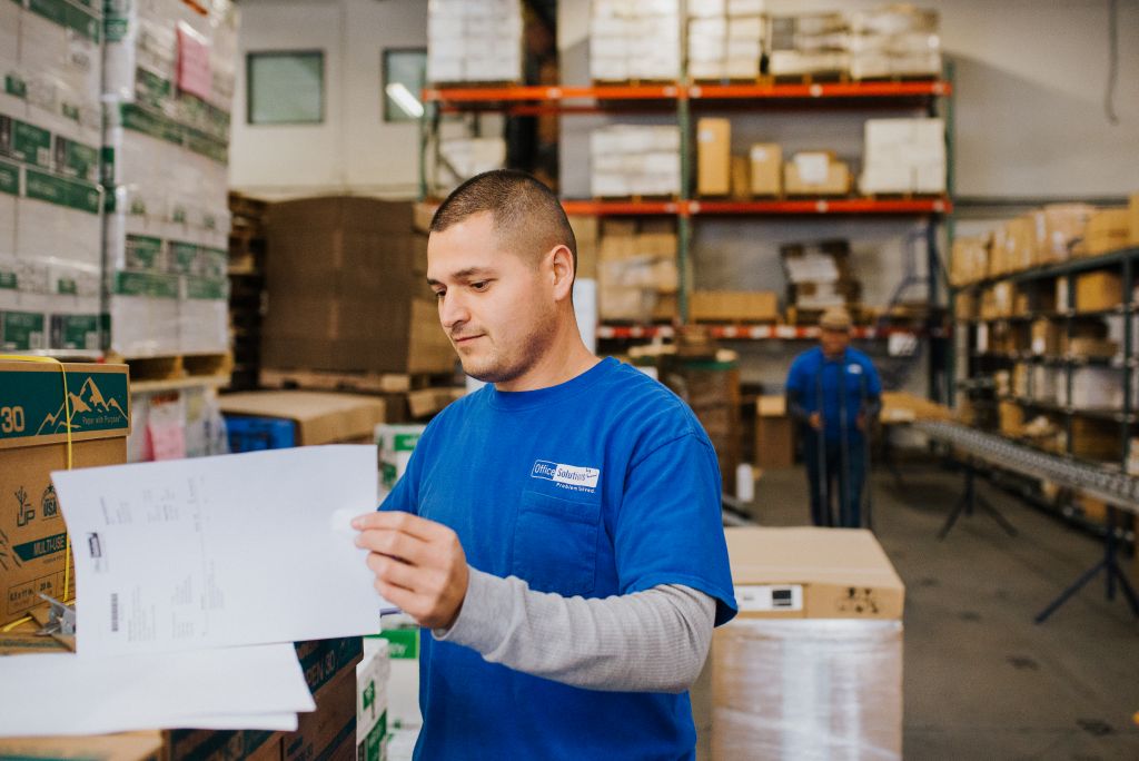 Our employee prepares paperwork in the warehouse.