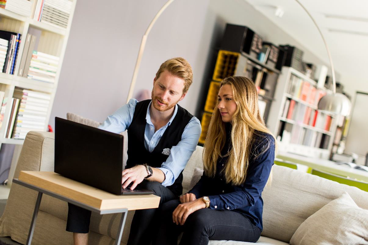 Employees reviewing products together on a laptop